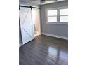 Bedroom with modern gray flooring, neutral walls, and barn door leading to en-suite bathroom at 2405 Cross Nw St, Atlanta, GA 30318