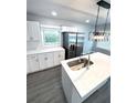 Modern kitchen with stainless steel appliances, white cabinets, and stylish center island at 2405 Cross Nw St, Atlanta, GA 30318