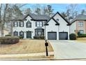 Two-story house with a two-car garage, painted white with black trim and windows on a winter lawn at 901 Blue Sky Rdg, Snellville, GA 30078