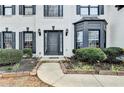 Close up of front entrance showing black door, bay window, dark trim and neatly manicured shrubs at 901 Blue Sky Rdg, Snellville, GA 30078