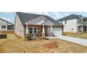 Lovely single Gathering home with stone and white accents and a two car garage at 6902 Winchester Pl, Fairburn, GA 30213