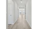 Bright hallway with light wood flooring, white walls and natural light at 6902 Winchester Pl, Fairburn, GA 30213