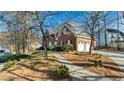Beautiful brick home with an attached garage, surrounded by trees and lush landscaping at 5679 Brookstone Nw Walk, Acworth, GA 30101