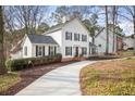 Traditional home with black shutters, white siding, manicured landscaping, and a long concrete driveway at 2828 Saddlebrook Nw Way, Marietta, GA 30064