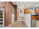 Hallway featuring exposed brick, white wainscoting, and entrance to the kitchen at 616 N Highland Ne Ave # 13B, Atlanta, GA 30306