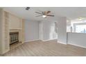 Open-concept living room with fireplace, shelving, modern ceiling fan, and new flooring at 669 Hunting Creek Se Ln, Conyers, GA 30013