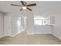 Bright and airy living room featuring a ceiling fan and an open view into the kitchen at 669 Hunting Creek Se Ln, Conyers, GA 30013