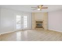 Cozy living room features fireplace with built-in shelving and french doors to the backyard at 669 Hunting Creek Se Ln, Conyers, GA 30013