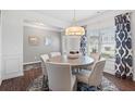Cozy dining area with a round table, six chairs, and elegant decor, illuminated by a contemporary chandelier at 525 Lanier Way, Temple, GA 30179