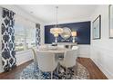 Elegant dining room featuring a modern chandelier, stylish decor, and ample natural light from the large window at 525 Lanier Way, Temple, GA 30179