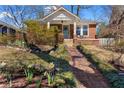 Quaint brick home featuring a welcoming front porch and beautifully landscaped front yard at 902 Edgewood Ne Ave, Atlanta, GA 30307