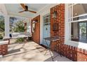 Inviting front porch features a swing, ceiling fan, brick columns, and a view into the home at 902 Edgewood Ne Ave, Atlanta, GA 30307