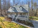 Elevated view of a charming two-story home featuring a cozy front porch and a well-manicured lawn surrounded by mature trees at 504 Hanover Ct, Woodstock, GA 30188