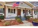 Inviting front porch with rocking chair, swing, and American flag, perfect for relaxing outdoors at 6710 River Springs Ct, Atlanta, GA 30328