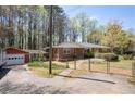 Brick ranch home featuring a fenced yard, a garage, and a covered side porch at 4693 Sugar Hill Se Rd, Acworth, GA 30102