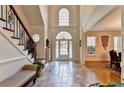 Grand foyer featuring soaring ceilings, tile flooring, staircase, and abundant natural light at 515 Butler National Dr, Johns Creek, GA 30097