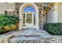 Close-up of the elegant front door with stone surround, decorative glass, and stone steps at 515 Butler National Dr, Johns Creek, GA 30097