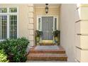 Close-up of front door with decorative planters and sidelights; a brick stoop and transom window at 15 Paces West Nw Dr, Atlanta, GA 30327