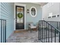 Cozy front porch seating area with black door, wreath, and oval window at 261 Thompson St, Alpharetta, GA 30009