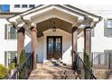 Close-up of a covered brick porch with dark wood columns and front door, offering a welcoming entrance at 1200 Primrose Park Rd, Sugar Hill, GA 30518