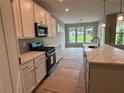 New kitchen with stainless steel appliances and white cabinets; island in the foreground at 125 Laurel Farms Ln, Dallas, GA 30157