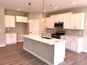 Bright kitchen with white cabinetry, a marble island, stainless steel appliances, and wood floors at 125 Laurel Farms Ln, Dallas, GA 30157