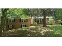 Classic brick home with black shutters, green lawn, and mature trees providing shade at 3879 Artist Vw, Decatur, GA 30034