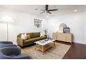 Bright living room with a modern ceiling fan, stylish furnishings, and sleek dark hardwood flooring at 1244 Lorenzo Sw Dr, Atlanta, GA 30310