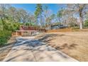 Exterior view of home with a long driveway, privacy fence, and mature trees at 3398 Lori Ln, Atlanta, GA 30340