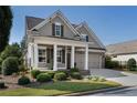 Attractive home featuring a manicured lawn, cozy porch, and convenient two-car garage at 3470 Serenade Nw Commons, Kennesaw, GA 30152