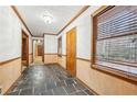 Hallway features dark tile floors, wood trim, and a window with natural light at 357 Forest Lake Rd, Lawrenceville, GA 30046