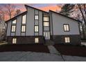Striking two-story home with stone base, modern siding, and large windows at dusk at 4013 Brenteresa Ct, Snellville, GA 30039