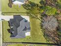 Aerial view of a home with a large roof, big yard, and mature trees surrounding the property at 1011 Nours Cir, Lawrenceville, GA 30045