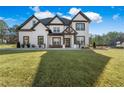 Beautiful home featuring a well-manicured lawn, a covered porch, and white and black trim at 1011 Nours Cir, Lawrenceville, GA 30045