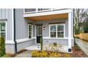 Covered front porch featuring a black door, white window trim, and modern exterior lighting at 1593 Roswell Se St, Smyrna, GA 30080