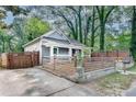 Landscaped front yard enclosed by horizontal and vertical wooden fencing and a paved driveway at 833 N Grand Nw Ave, Atlanta, GA 30318