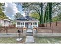 Charming gray home with a welcoming front yard enclosed by a decorative fence, offering curb appeal at 833 N Grand Nw Ave, Atlanta, GA 30318