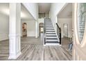 Bright foyer with soaring ceilings, a staircase with black iron railings, and gray wood-look floors at 3772 Sunbridge Dr, Snellville, GA 30039