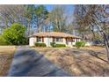 A ranch style home on a lot with green landscaping featuring a long driveway at 2940 Stonecreek Se Rd, Smyrna, GA 30080