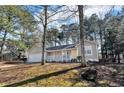 Inviting single-story home featuring a cozy front porch, set amongst mature trees at 50 Riverside Ct, Hampton, GA 30228