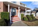 Inviting front porch with red-painted steps and white railings, framed by lush green bushes at 1191 Fountain Head Ct, Lawrenceville, GA 30043