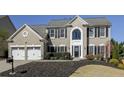 Charming two-story home with a well-manicured lawn and a two-car garage, all under a clear blue sky at 5446 Oxford Chase Way, Dunwoody, GA 30338