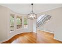 Bright dining room featuring hardwood floors, a modern chandelier, and an abundance of natural light at 1655 Fate Conn Rd, Canton, GA 30114