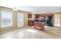 Eat-in kitchen features cherry cabinets, a center island, tile floors, and modern black appliances at 5027 Estonian Dr, Fairburn, GA 30213
