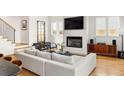 Living room featuring a fireplace, large TV, sleek chairs, modern sofa, and hardwood floors at 56 Walthall Ne St, Atlanta, GA 30307