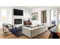 Bright living room with a modern fireplace, large TV, sleek chairs, and comfortable seating arrangement at 56 Walthall Ne St, Atlanta, GA 30307