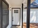 Close up of a white front door with a multi-pane window and black trim at 9377 Woodloop Ct, Jonesboro, GA 30238