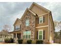 Beautiful home with a combination of stone and siding, complemented by dark shutters and a well-maintained yard at 8340 Nolandwood Ln, Villa Rica, GA 30180
