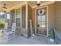 Cozy front porch with rocking chairs, a decorative wreath, and a 'Welcome' sign, creating a warm entrance at 8340 Nolandwood Ln, Villa Rica, GA 30180
