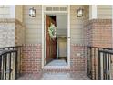 Welcoming front entrance with brick accents, decorative wreath, and stylish lighting fixtures at 3930 Covey Flush Sw Ct # 21, Smyrna, GA 30082